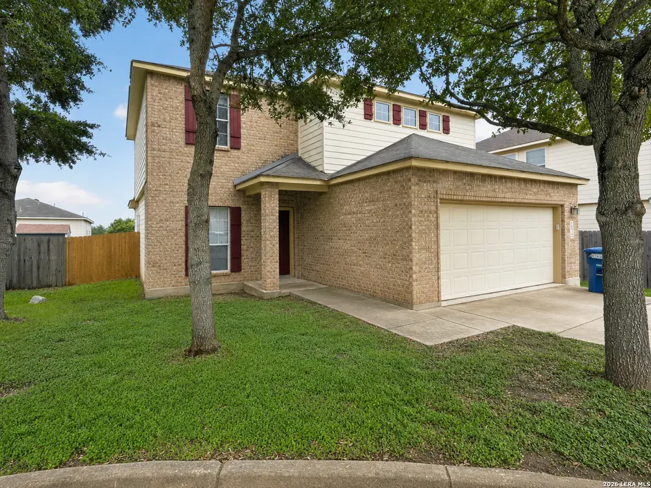 Brick front of 3826 Otono with red shutters and the two-car garage